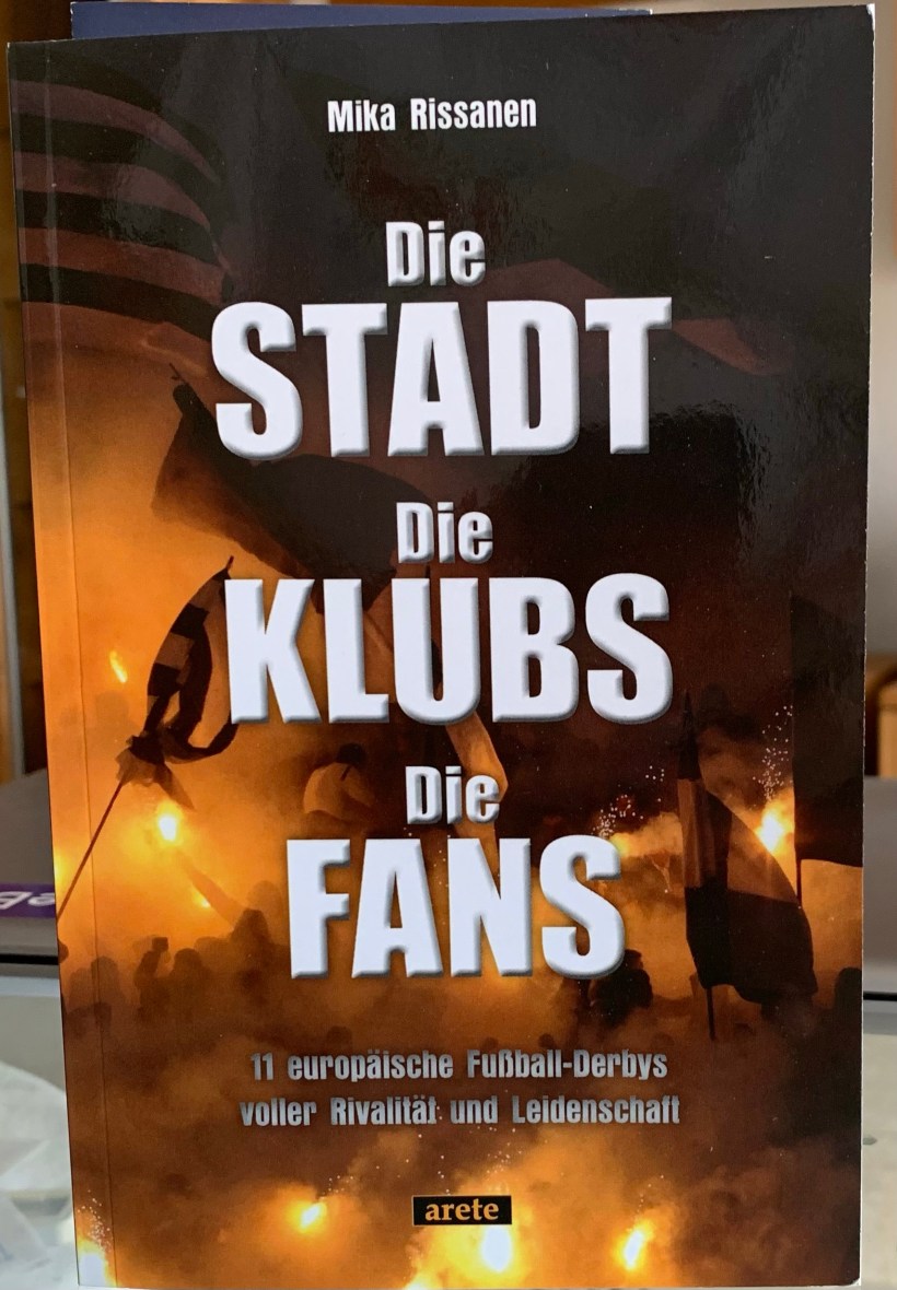 Buchtitel „Die Stadt Die Klubs Die Fans. Ansicht eines Fanblocks (Fußball) mit Fahnen und Pyrotechnik (Rauch und Fackeln)